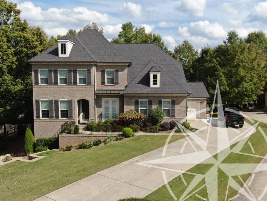 Two-story brick house with a driveway, front lawn, and a black SUV parked outside