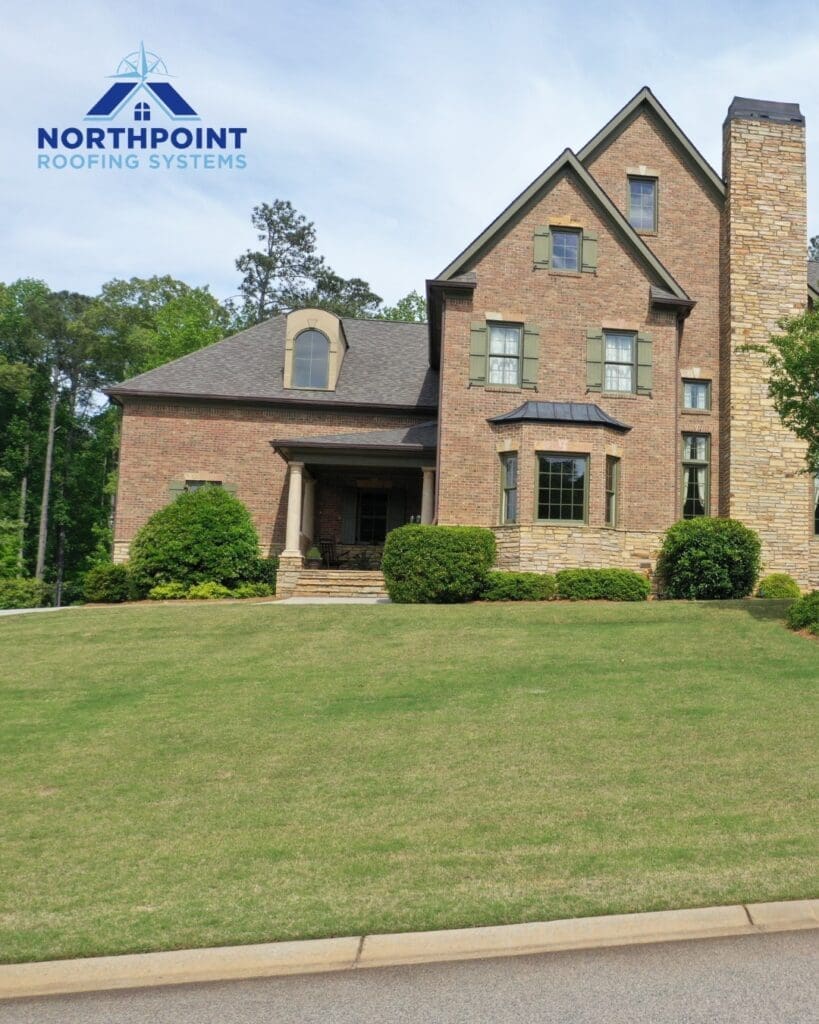 Northpoint Roofing Systems logo over a brick house with a new roof